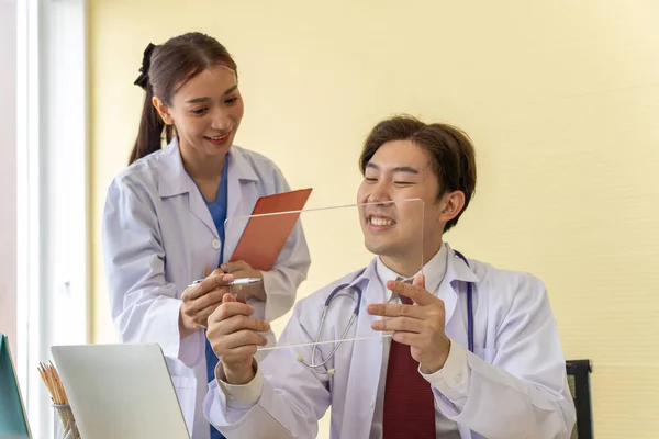 年轻的博士先生在虚拟现实中拥有空白透明的平板电脑 为用户在视觉中插入设计的创新 美丽的医生站在一起凝视着 面向未来的医疗保健理念 — 图库照片