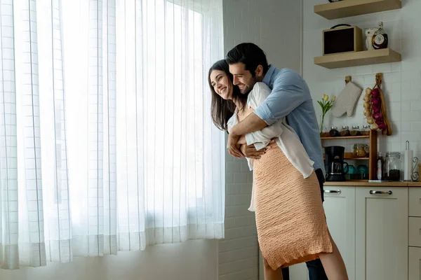 Attractive young couple embracing with happy, They have spending romantic time together in kitchen at home, copy space