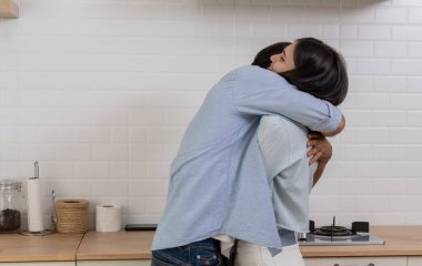 Mutfakta kucaklaşan romantik sevgili, evlenme teklif eden genç yakışıklı adam, kız arkadaşına sürpriz yapmak için bir yüzük ver, ona evde evlenme teklif et, birlikte evlensinler.