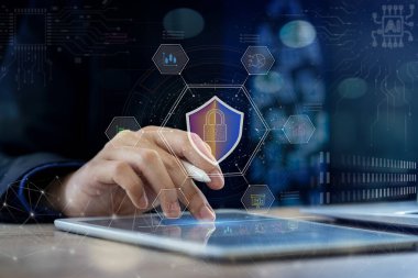 İşadamı dijital bir kalem tutarken orta parmağıyla dijital tablet ekrana basarak ağ veri güvenliğini sağlıyor. Ekrandaki grafik simgesi bir ağ veri güvenlik kilidini betimliyor. İş güvenliğinizi arttırın ve işinizi koruyun.