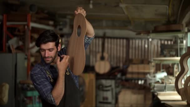 Wykwalifikowany Lutnik Ciężko Pracuje Szlifując Ciało Gitary Akustycznej Swoim Warsztacie — Wideo stockowe