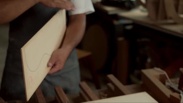 熟練したルシエは ワークショップでアコースティックギターの本体をサンディングするのが難しい 細部への注意は ルシエの手とギターのクローズアップビューで明らかです — ストック動画