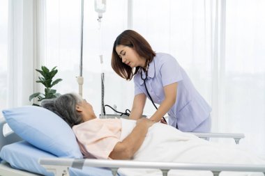 Günlük teftiş. Yaşlı bir hastanın bakıcısı ya da hemşiresi hastanın kan basıncını ve kalp atışını ölçmeye hazırlanıyor. Hastanelerde ya da kliniklerde hastalara hemşireler bakar.