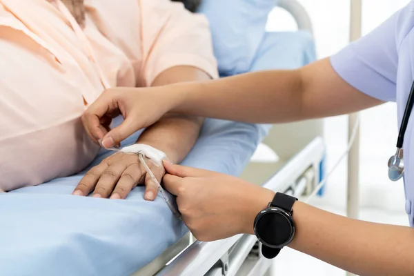 Hospitalization of the patient. Nurse takes care of patients in nursing home or hospital. nurse are verifying the accuracy of giving Saline to patients. Caregiver or nurse and senior concept.
