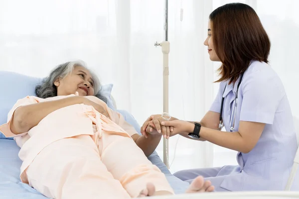 Caregiver or nurse and senior concept. A nurse is providing emotional support to a patient who is under stress related to her illness. Nurse takes care of patients in nursing home or hospital.