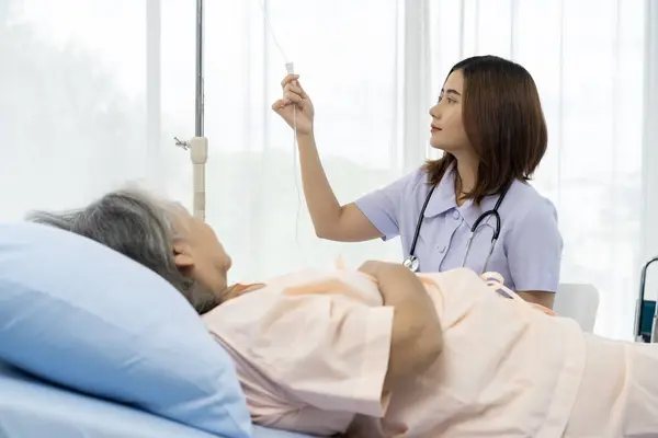 A nurse or caregiver for an elderly patient is adjusting the normal rate of medical saline given to the patient based on the detected medical condition. Nurse takes care of patients in hospital.