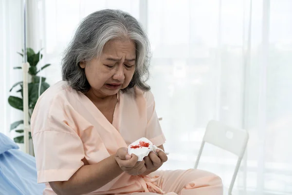Elderly Asian patient admitted to hospital She had a cough so violent that she bled while sitting in a hospital bed. Nurses care for patients in hospitals or clinics.