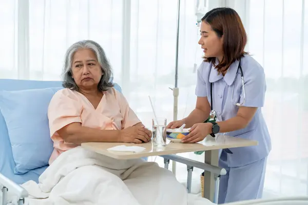 Elderly Asian patient admitted to hospital during treatment The nurse is caring for and feeding a patient, but she has anorexia. A nurse takes care of patients in a hospital or clinic.