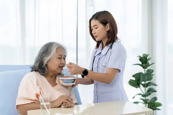 Elderly Asian patient admitted to hospital During the treatment period Nurses would care for her and feed patients who were unable to care for themselves. A nurse takes care of patients in a clinic.