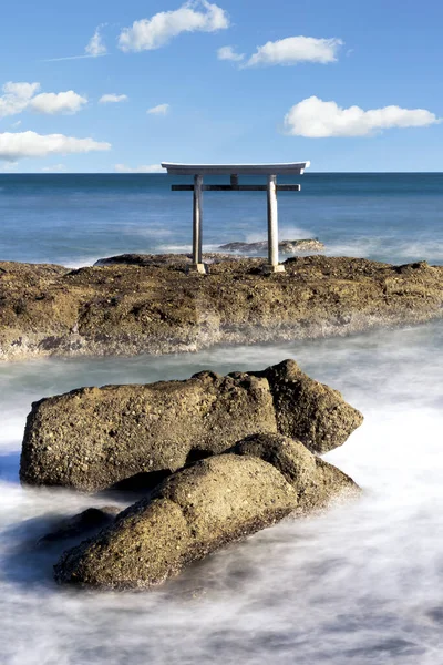 Japonya 'daki Oarai Isosaki Tapınağı' nda okyanusta yüzen bir torii kapısının çarpıcı fotoğrafı. Bu ikonik görüntü Japon kültürünün ve maneviyatının sembolüdür..