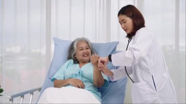 Orta boy iğne, genç bir kadın doktor koğuştaki yaşlı bir kadının kalp atışlarını kontrol ediyor. Bir tıp uzmanı hastanın bileğini tutarak nabzını kontrol eder..