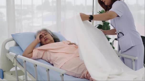 一名老年病人的护士或护理人员正在帮躺在床上的病人盖被子 在医院或诊所护理病人的护士 — 图库视频影像