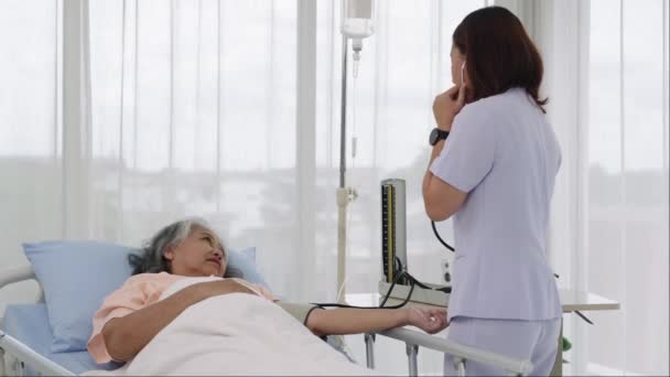 ハンドヘルドショット 高齢者の看護師または介護者は 患者の血圧と心拍数を測定する 病院やクリニックの患者さんのケア — ストック動画
