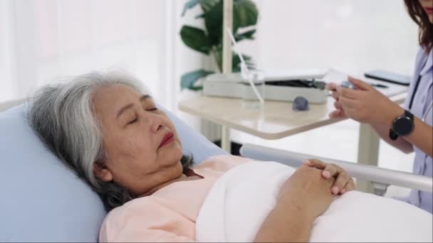 手持枪弹 年长的亚洲病人入院 她咳嗽发烧 护士用数字温度计量体温 在医院或诊所护理病人的护士 — 图库视频影像