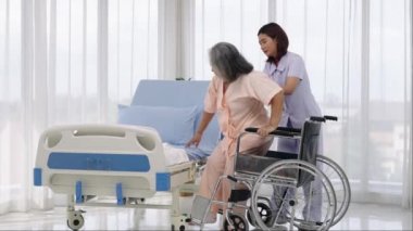 Bir hemşire, bir kazada bacağının röntgenini çektirmek için yaşlı bir Asyalı hastayı tekerlekli sandalyeye taşıyor. Hemşire, hastane ya da klinikte hastalara bakar..
