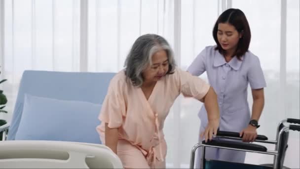 ハンドヘルドショットの看護師は 高齢のアジアの患者を車椅子に乗せて 事故で足のX線を負傷させました 看護師が病院やクリニックで患者の世話をします — ストック動画