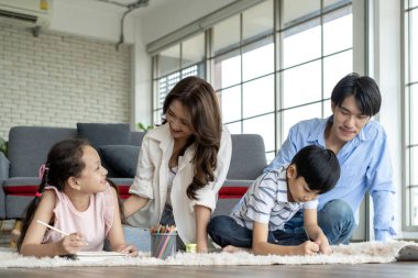 Ebeveynler çocuklarını oturma odasında çizim yapmaya teşvik eder ve eğlenirler. Çocuklar, oturma odasında aile mutluluğu çizerken eğlenin.