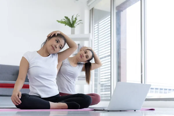 two women sitting on a yoga mat in lotus position captures the essence of peace and tranquility. It is a perfect fit for any website or project that promotes wellness, fitness, or mindfulness.