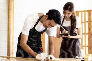 İki kahve dükkanı sahibi, bir dizüstü bilgisayarla dükkanlarının planlarını tartışarak bir yenileme projesinde işbirliği yapıyorlar.. 