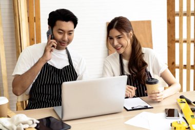 İki kahve dükkanı sahibi, bir dizüstü bilgisayarla dükkanlarının planlarını tartışarak bir yenileme projesinde işbirliği yapıyorlar.. 