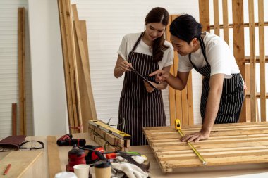 İki kahve dükkanı sahibi, bir dizüstü bilgisayarla dükkanlarının planlarını tartışarak bir yenileme projesinde işbirliği yapıyorlar.. 