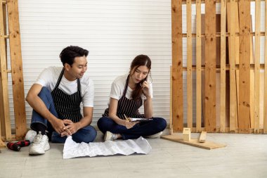 İki kahve dükkanı sahibi, bir dizüstü bilgisayarla dükkanlarının planlarını tartışarak bir yenileme projesinde işbirliği yapıyorlar.. 