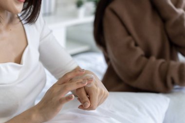 Fotoğrafı kapat. Rahat kadın, yatak odasının sükunetinde krem sürerek ellerini nemlendiriyor. Doğal ışıklandırma yaşam tarzı görüntüsü, sağlık hizmetleri uygulamaları..