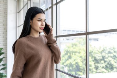 Uzun siyah saçlı neşeli bir genç kadının hayat tarzı. Bir telefon görüşmesi yapıyor. Gün boyunca büyük bir cam pencerenin yanında dikiliyor..