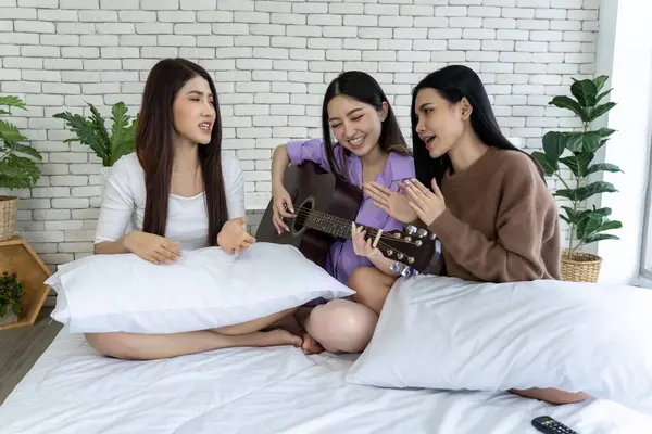 Bir grup mutlu arkadaş bir yatakta şarkı söylüyor ve gitar çalıyorlar. Çok eğleniyorlar ve müzik odayı neşeyle dolduruyor..