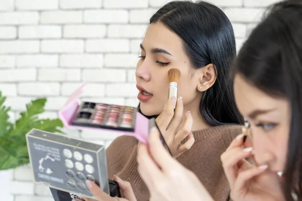 Woman makeup face with brush applying make-up product, Cosmetic glow, Skin care, blush and foundation, Conturing and highlighting lines on beauty woman face, smooth skin and fresh makeup.