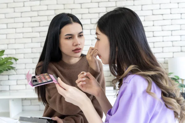 Woman makeup face of friend with brush applying make-up product, Cosmetic glow, Skin care, blush and foundation, Conturing and highlighting lines on beauty woman face, smooth skin and fresh makeup.