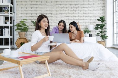 Yatma zamanı sosyal medya titreşimleri, yatakta genç kadınlar, dizüstü bilgisayarlar, kahve eşliğinde sohbet. Bu rahat ortamda eğlenceli anlar ve çeşitli konuşmalar paylaşan dijital bağlantıların neşesini keşfedin