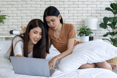 Lgbtq +, çift ve evde sosyal medyada dizüstü bilgisayarla rahatlayın. Yatak odasındaki bir yatakta yatan iki genç kadın bir dizüstü bilgisayardaki sosyal medya sohbetine daldılar..