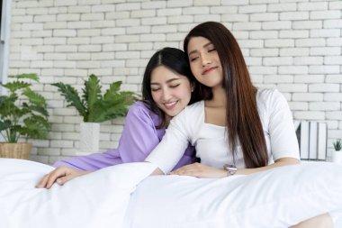 Çekici lezbiyen çift yatak odasında yatarken samimi bir kucaklaşmayı paylaşıyor, kadın lgbtq + partnerleri arasında romantik bir anı yakalıyor şefkatli bir sabah kucaklaşması yaşıyor..