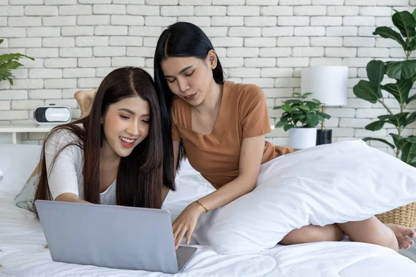Lgbtq +, çift ve evde sosyal medyada dizüstü bilgisayarla rahatlayın. Yatak odasındaki bir yatakta yatan iki genç kadın bir dizüstü bilgisayardaki sosyal medya sohbetine daldılar..