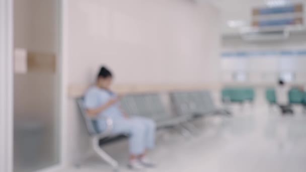 병원이나 진료소에서 복도의 검사실 앞에서 의사를보고 앉아있는 의료진과 환자의 카운터 — 비디오