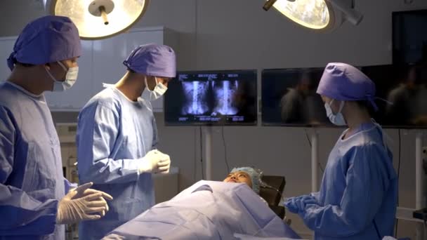 手持射击 外科医疗队在手术室病床上与女病人交谈 医护专业人员在外科谈话方面的专业知识 确保病人在手术过程中的最佳理解 — 图库视频影像
