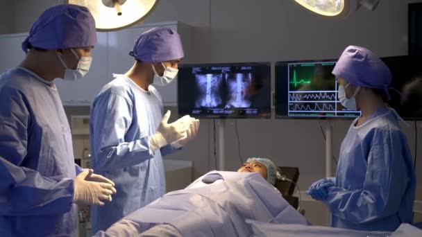 手持射击 外科医疗队在手术室病床上与女病人交谈 保健专业人员在手术麻醉前讨论外科手术的专门知识 — 图库视频影像