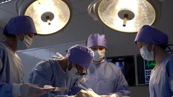 Strzał Ręczny Zespół Profesjonalnych Chirurgów Wykonuje Zabieg Pacjencie Pod Znieczuleniem — Wideo stockowe