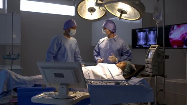 手持射击 外科医疗队在手术室病床上与女病人交谈 医护专业人员在外科谈话方面的专业知识 确保病人在手术过程中的最佳理解 — 图库视频影像