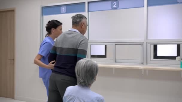 Handschwenkschuss Älterer Mann Geht Mit Stock Zum Kassenschalter Des Krankenhauses — Stockvideo