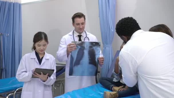 手持拍摄 非裔美国父亲安慰小女儿 同时等待两名医生在医院急诊室用胸部X光片进行诊断 — 图库视频影像