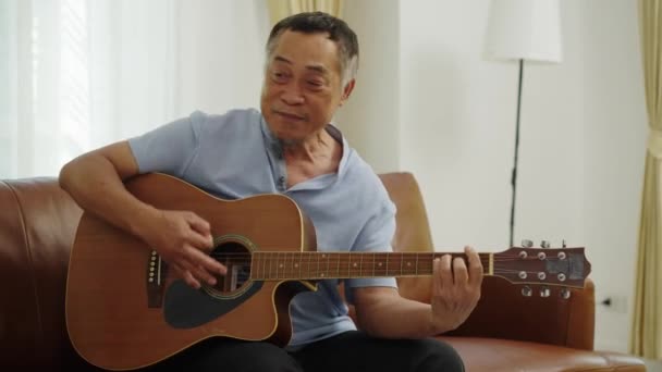 Handhållen Medium Shot Asiatisk Pensionerad Man Med Sittande Soffan Vardagsrummet — Stockvideo