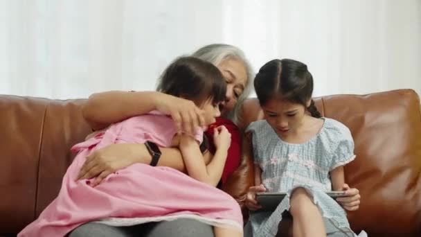 Filmagem Tiro Médio Portátil Avó Sentado Sofá Abraçando Menina Comendo — Vídeo de Stock