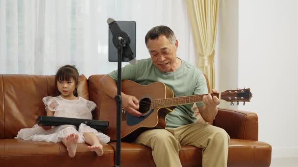 Záběry Handheld Střední Shot Asijské Důchodce Hraje Kytaru Zpěv Vnučka — Stock video