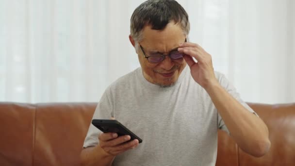 Съемки Крупным Планом Пожилой Человек Очках Сидящий Диване Гостиной Расслабление — стоковое видео