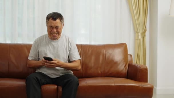 Filmagem Handheld Médio Tiro Asiático Aposentadoria Homem Sentado Sofá Usando — Vídeo de Stock