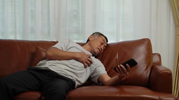 Съемки Ручным Увеличением Азиатский Пенсионер Использующий Мобильный Телефон Позвать Помощь — стоковое видео