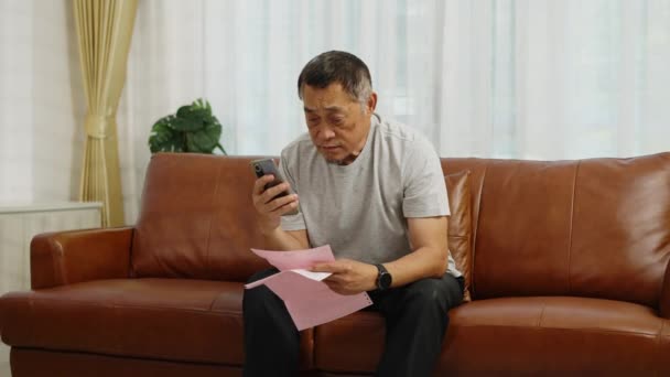 Πλάνα Χειρός Μέσο Πλάνο Ανησυχία Ασιάτης Συνταξιούχος Κάθεται Στον Καναπέ — Αρχείο Βίντεο