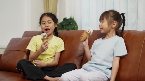 Görüntüler Kamerasıyla Çekilmiş Iki Asyalı Kardeş Kanepeye Oturmuş Elinde Çikolatalı — Stok video